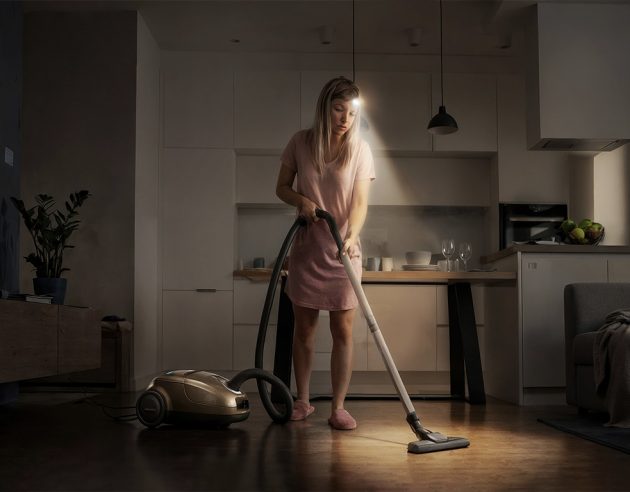 Vrouw die stofzuigt met een hoofdlamp aan
