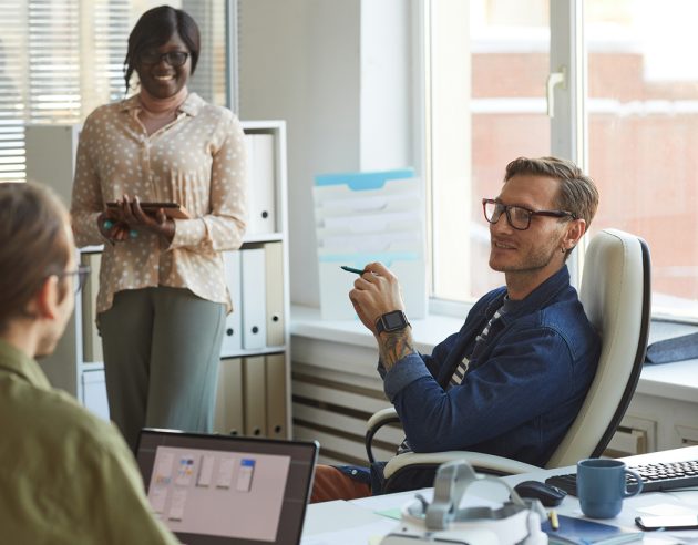 3 mensen aan het vergaderen aan een bureau